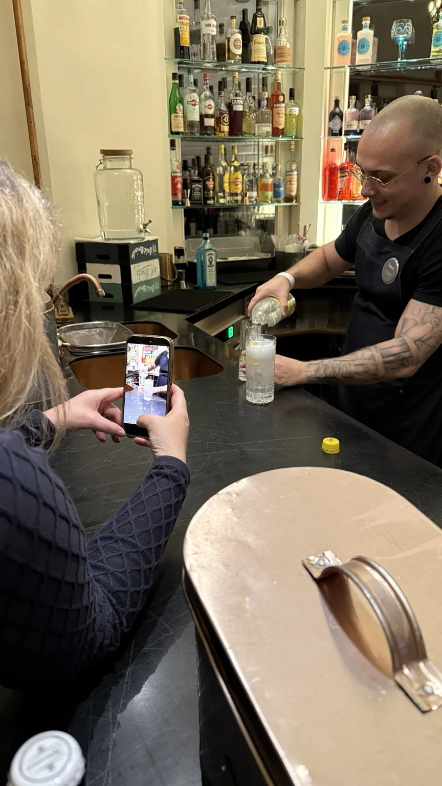 Cordula filmt einen Barkeeper bei der Contentproduktion
