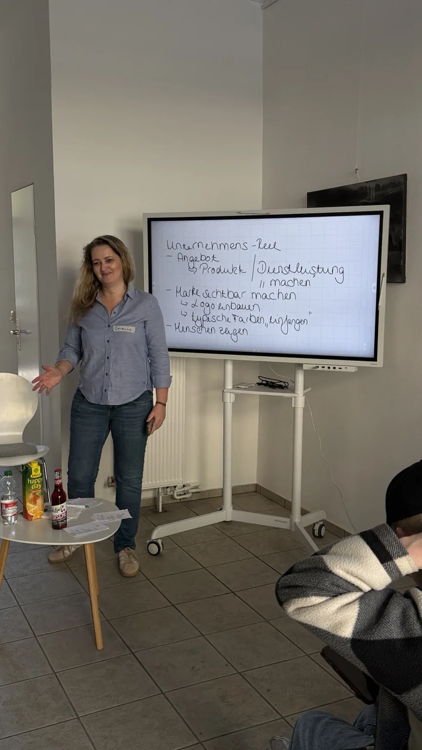 Cordula erklärt Unternehmenskommunikation an einem digitalen Board